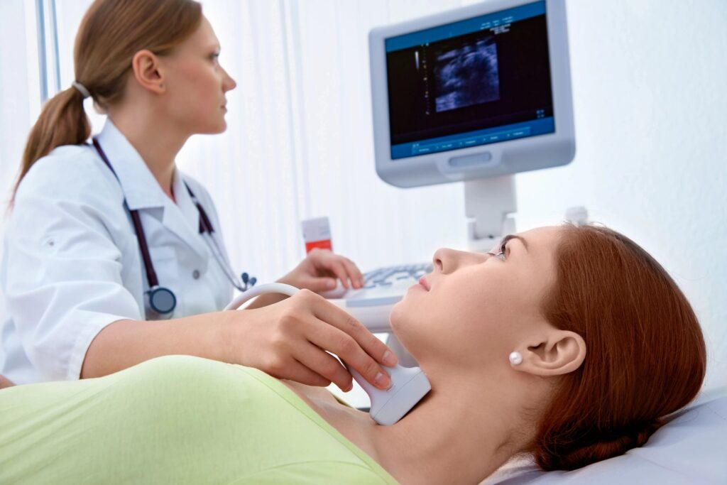 A woman is getting her thyroid checked by an obstetrician.