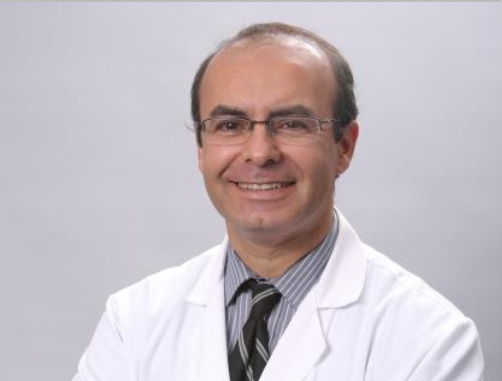 A man in white lab coat and tie.